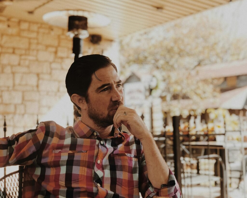 אדם יושב בבית קפה, צילום להמחשת דאגות כלכליות; אינו פרופ׳ ממדוב